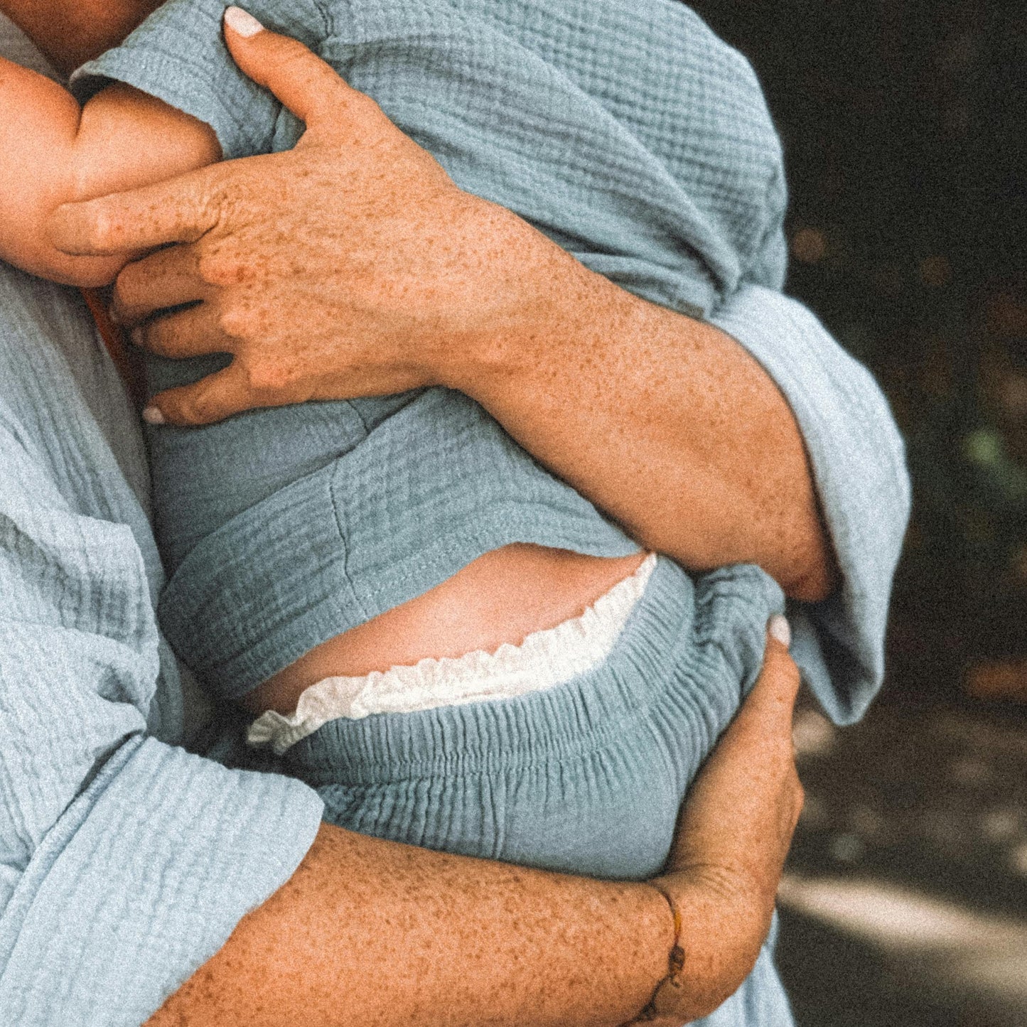 Mom Holding Babe Both Wearing Blue Gauze Shirts
